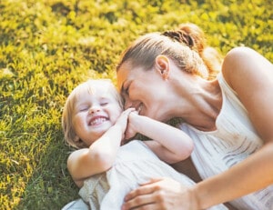 happy women with her child on the grass laughing