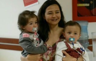 Woman carrying 2 kids